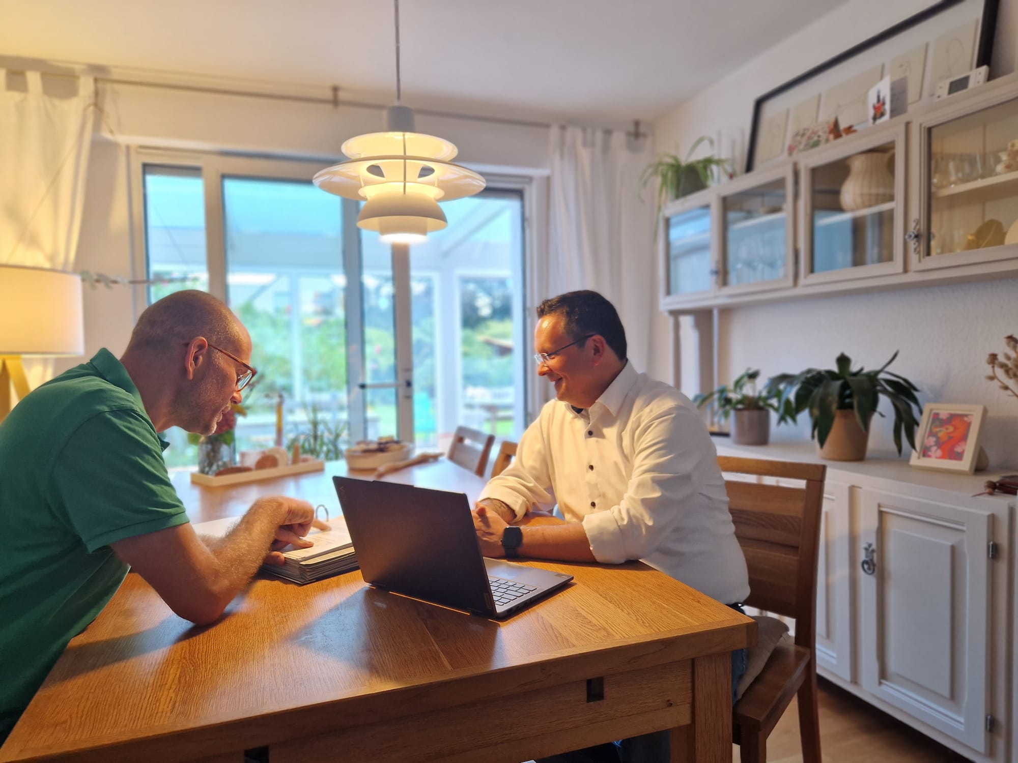 Tobias sitzt mit einem Kunden zusammen am Tisch und geht eine Baufinanzierung Neuss durch